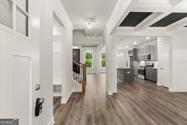 foyer entrance featuring hardwood / wood-style flooring, sink, and ornamental molding