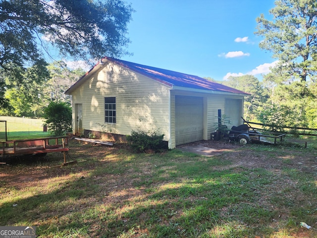 back of house featuring a garage and an outbuilding