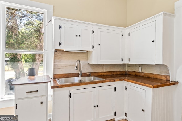 kitchen with white cabinetry, sink, tasteful backsplash, and a healthy amount of sunlight