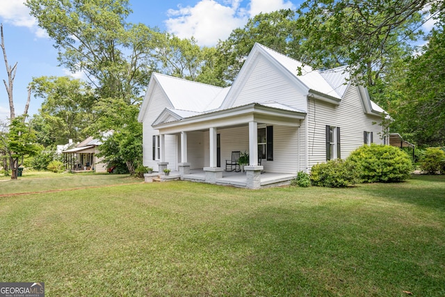 rear view of property with a yard and covered porch