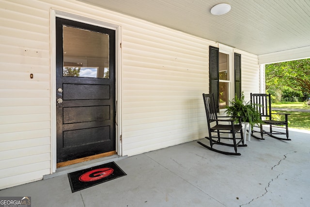 view of exterior entry featuring covered porch