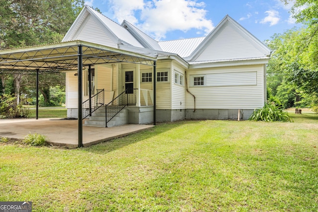 back of property featuring a carport and a lawn