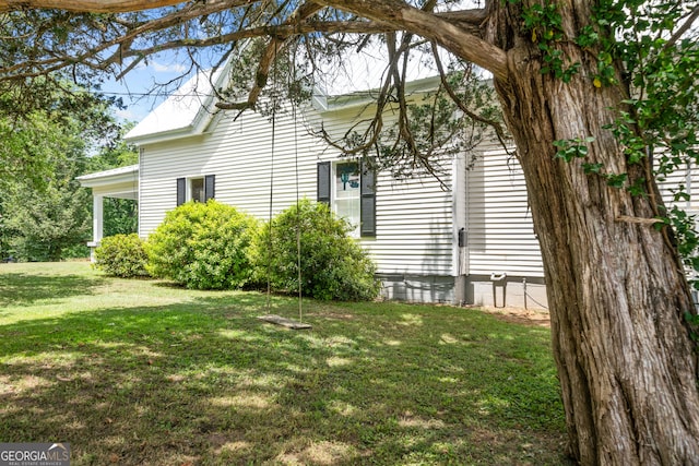 view of side of home with a lawn