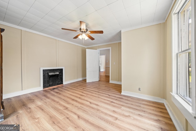 unfurnished living room featuring light hardwood / wood-style flooring, a high end fireplace, ornamental molding, and ceiling fan