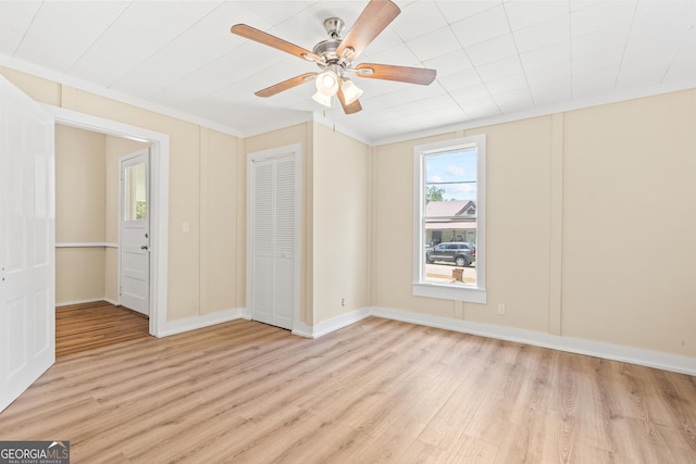 unfurnished bedroom featuring ceiling fan, a closet, and light wood-type flooring