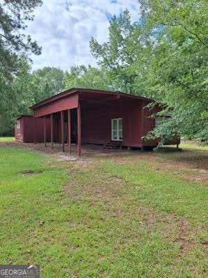 view of outdoor structure with a yard and a carport