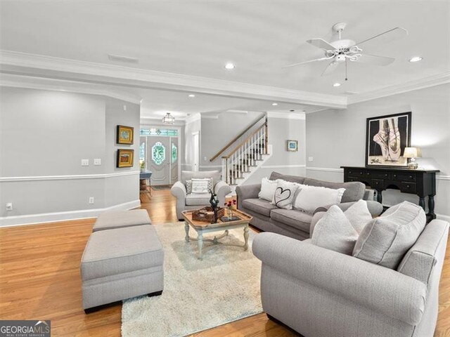 living room featuring ceiling fan, light wood-type flooring, and crown molding