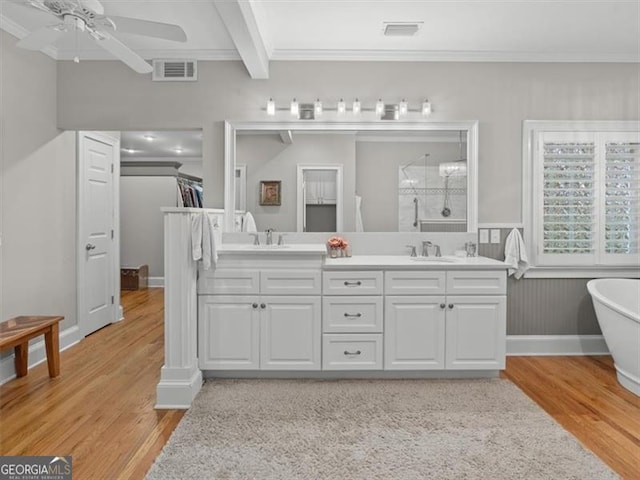 bathroom featuring a tub to relax in, dual vanity, beam ceiling, hardwood / wood-style flooring, and ceiling fan