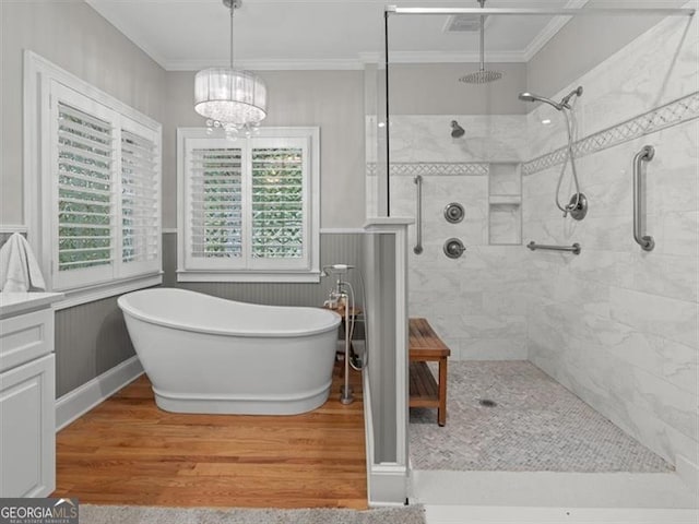 bathroom featuring independent shower and bath, hardwood / wood-style floors, ornamental molding, and a chandelier