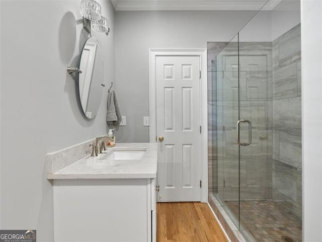 bathroom with a shower with shower door, vanity, and wood-type flooring