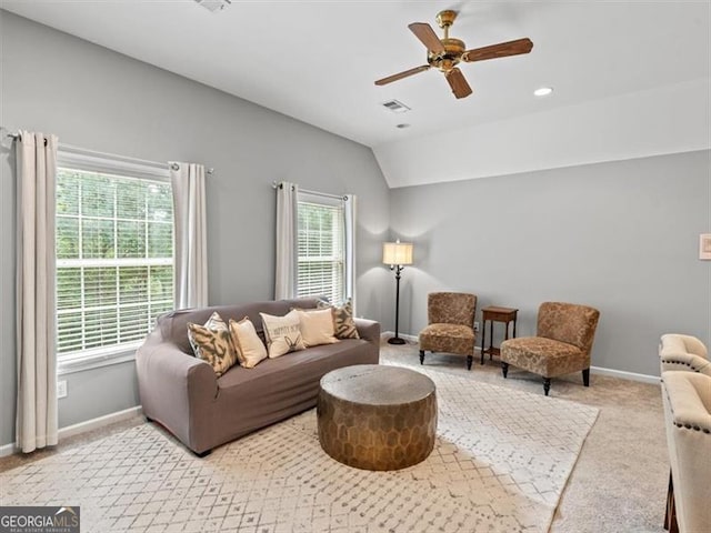 carpeted living room with ceiling fan and lofted ceiling