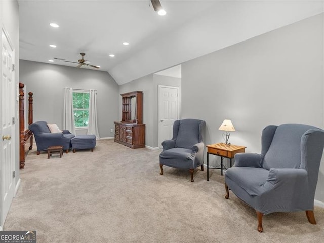 living area with ceiling fan, light carpet, and lofted ceiling