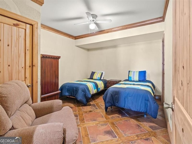 bedroom with ceiling fan, crown molding, and dark tile patterned floors