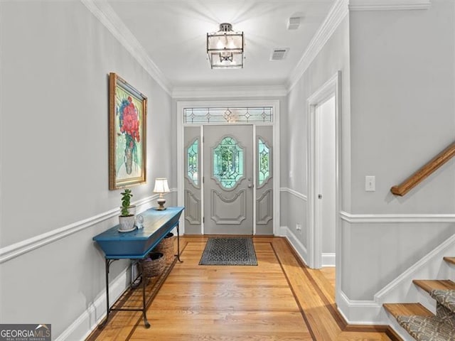 foyer entrance with crown molding and light hardwood / wood-style floors