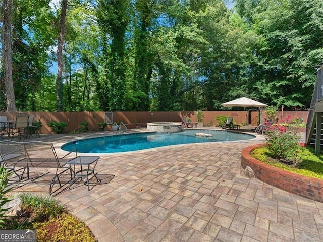 view of pool with an in ground hot tub and a patio