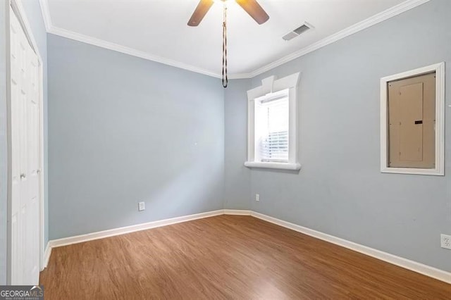 spare room with ceiling fan, crown molding, and wood-type flooring