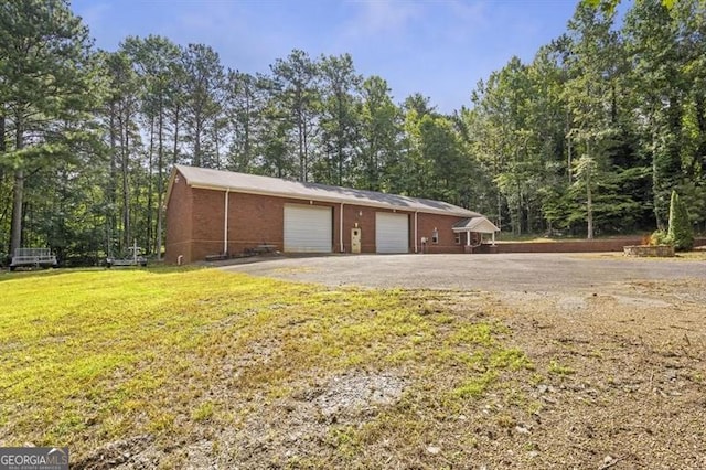 exterior space featuring a yard, an outdoor structure, and a garage