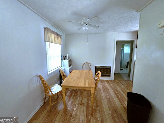 dining room featuring hardwood / wood-style flooring, a textured ceiling, and ceiling fan