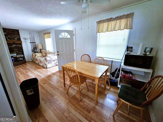 dining space with ceiling fan, a textured ceiling, hardwood / wood-style flooring, and a wealth of natural light