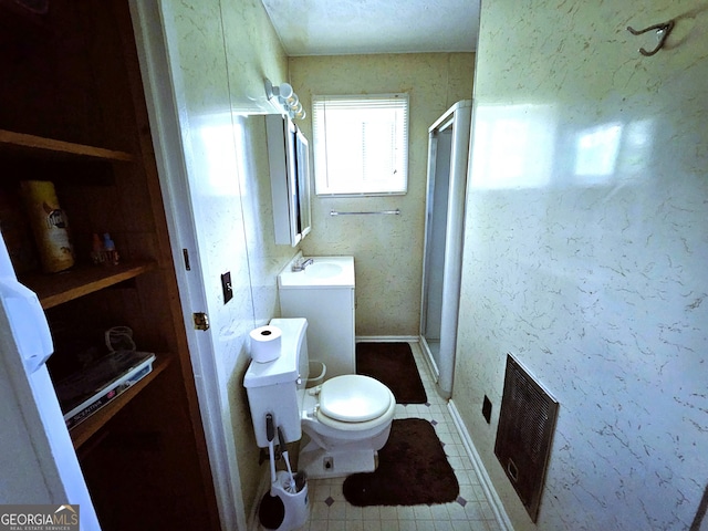 bathroom with tile patterned flooring, a shower with door, toilet, and vanity