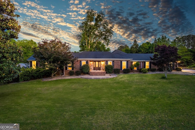 ranch-style home with a yard and brick siding