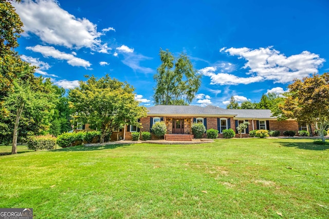 ranch-style home featuring brick siding and a front yard