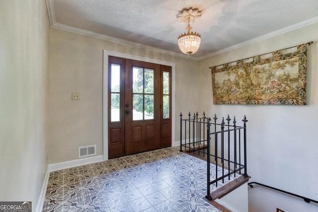 entryway with visible vents, baseboards, crown molding, and a notable chandelier