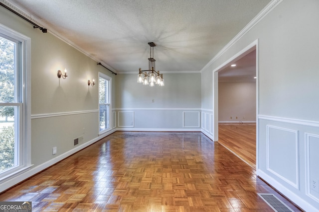 unfurnished dining area with visible vents, ornamental molding, and an inviting chandelier