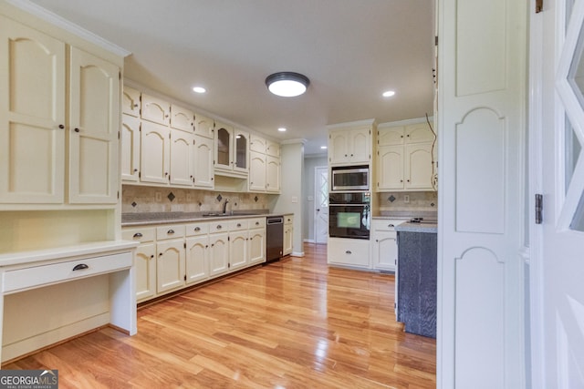 kitchen featuring light wood-type flooring, backsplash, and stainless steel appliances