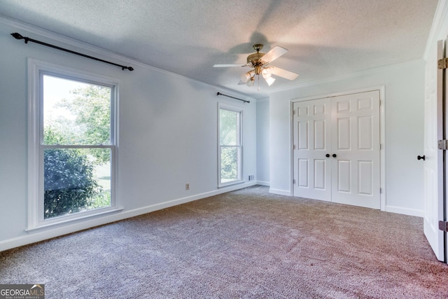 unfurnished bedroom with baseboards, a textured ceiling, carpet, and a closet