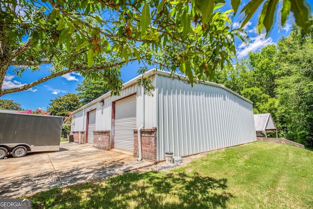 view of home's exterior featuring brick siding, a lawn, an outbuilding, and a detached garage