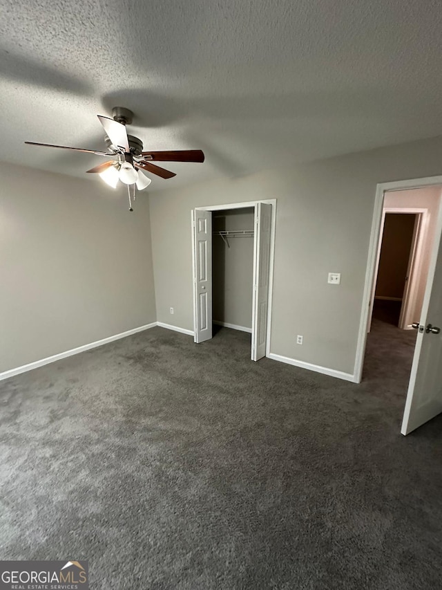 unfurnished bedroom featuring ceiling fan, a closet, dark carpet, and a textured ceiling