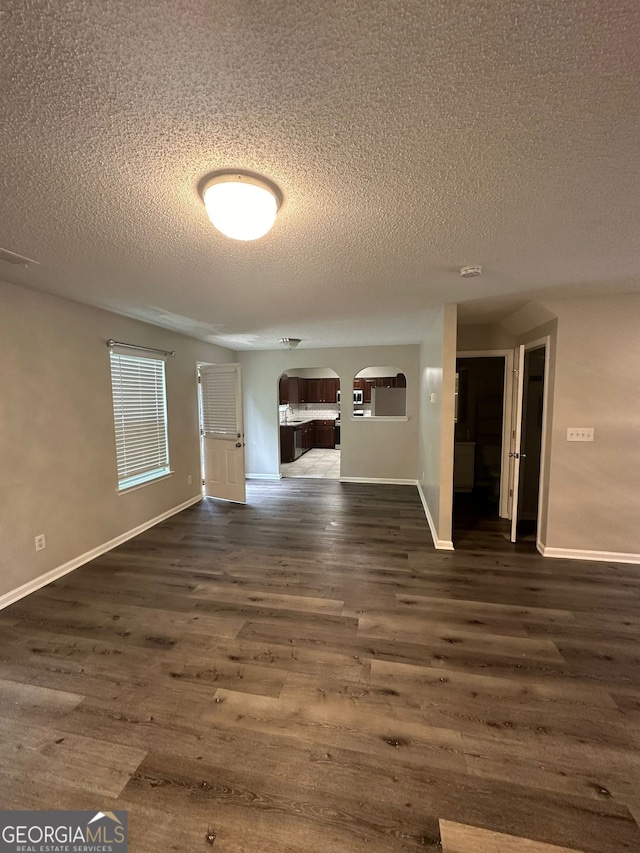 empty room featuring dark wood-type flooring and a textured ceiling