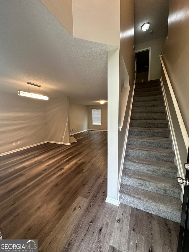 stairway featuring hardwood / wood-style floors and a textured ceiling