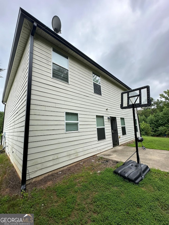 back of property with a patio area and a lawn