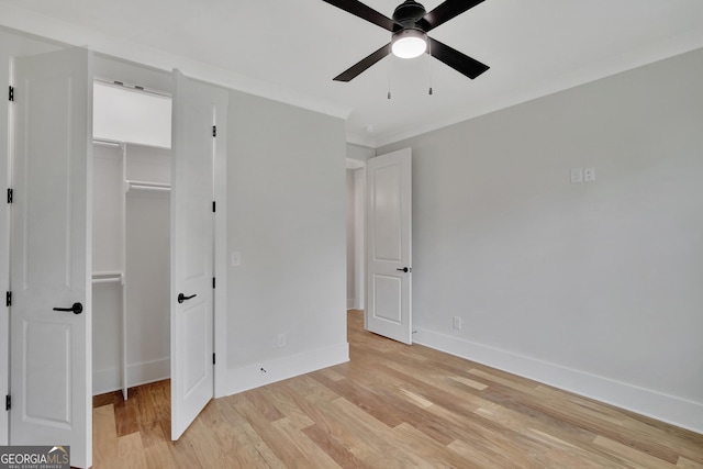 unfurnished bedroom featuring crown molding, light hardwood / wood-style floors, a closet, and ceiling fan