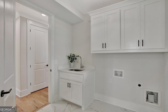 laundry area featuring electric dryer hookup, sink, hookup for a washing machine, and cabinets