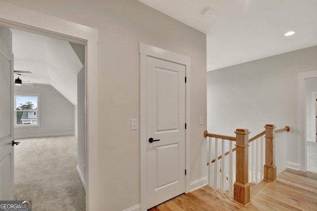 hallway featuring lofted ceiling and light hardwood / wood-style floors