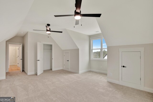 additional living space with vaulted ceiling, light carpet, and ceiling fan