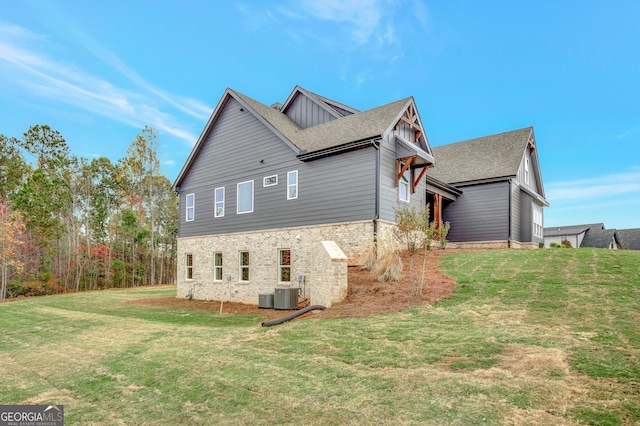 view of side of home with a lawn and central air condition unit