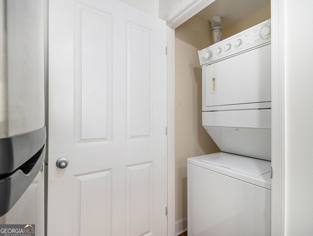 washroom featuring stacked washer / dryer and laundry area
