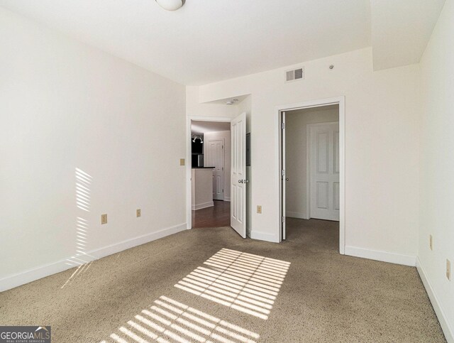 unfurnished bedroom featuring carpet, visible vents, and baseboards
