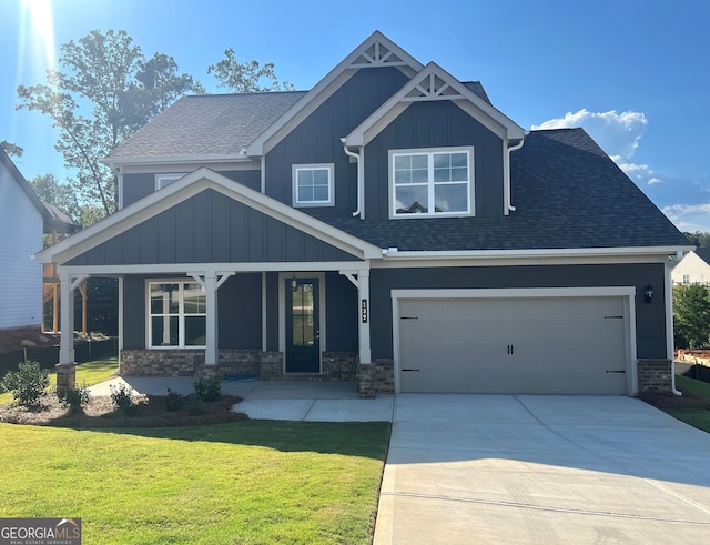 craftsman-style house featuring a front lawn, covered porch, and a garage