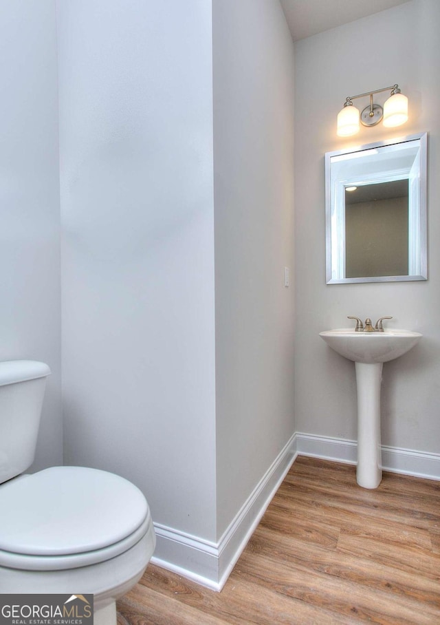 bathroom with hardwood / wood-style floors and toilet