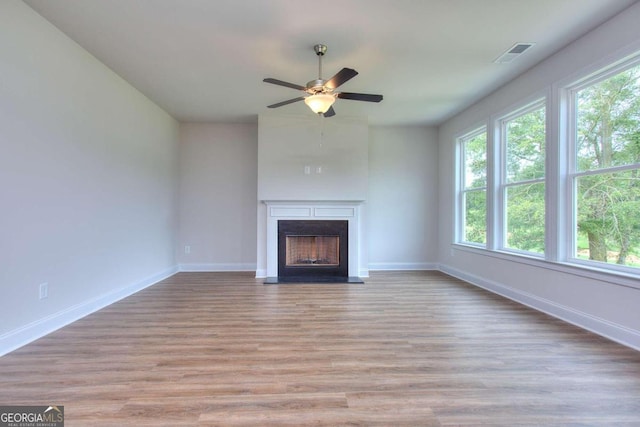 unfurnished living room with light wood-type flooring and ceiling fan