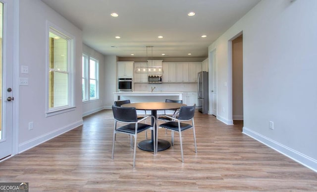 dining area with light hardwood / wood-style floors and sink