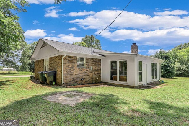 rear view of house featuring a yard