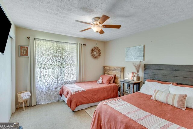 bedroom featuring ceiling fan, carpet flooring, and a textured ceiling