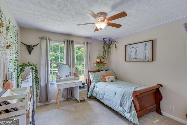 carpeted bedroom featuring a textured ceiling and ceiling fan