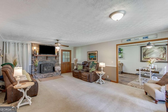 carpeted living room featuring ceiling fan, brick wall, a textured ceiling, and a brick fireplace